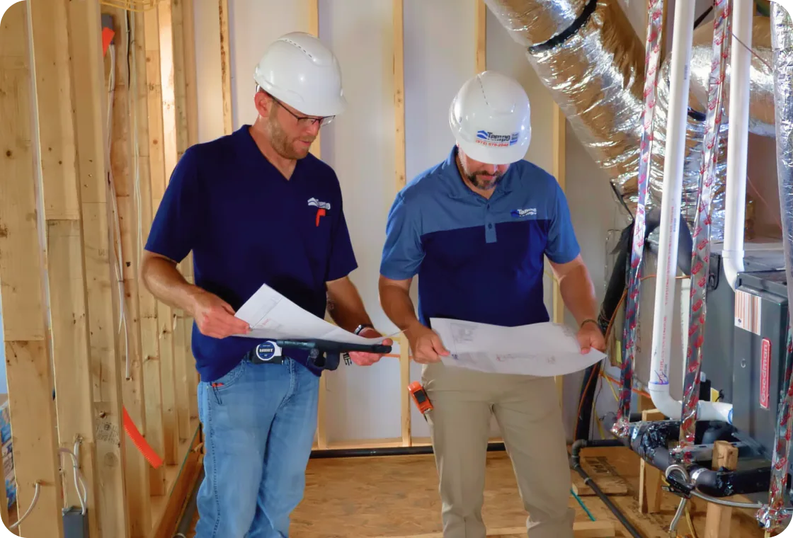 Tempo Mechanical team reviewing HVAC plans on a job site